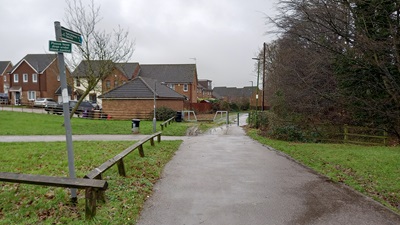 Photo along path from Great Ashby Way showing wide metalled route